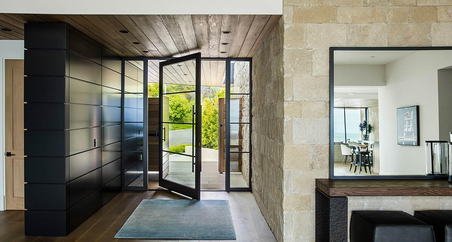 Modern steel pivot front door in Austin TX with large glass panels for luxury home entry