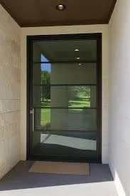 Oversized steel pivot entry door with dark frame and glass panels for a luxury Austin home Oversized steel pivot entry door with dark frame and glass panels for a luxury Austin home