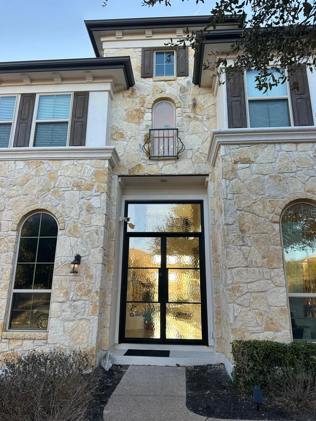 Black steel double entry door installed on a stone home in Dripping Springs, TX