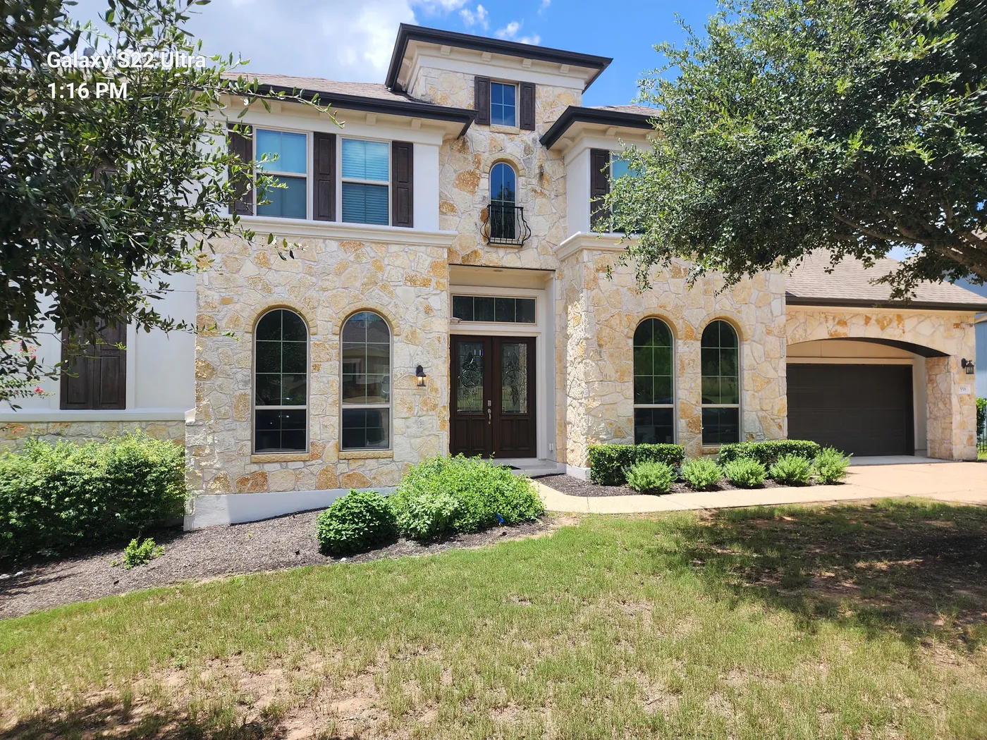 Exterior of the Dripping Springs Hill Country stone home where OMG Steel Doors replaced the entry