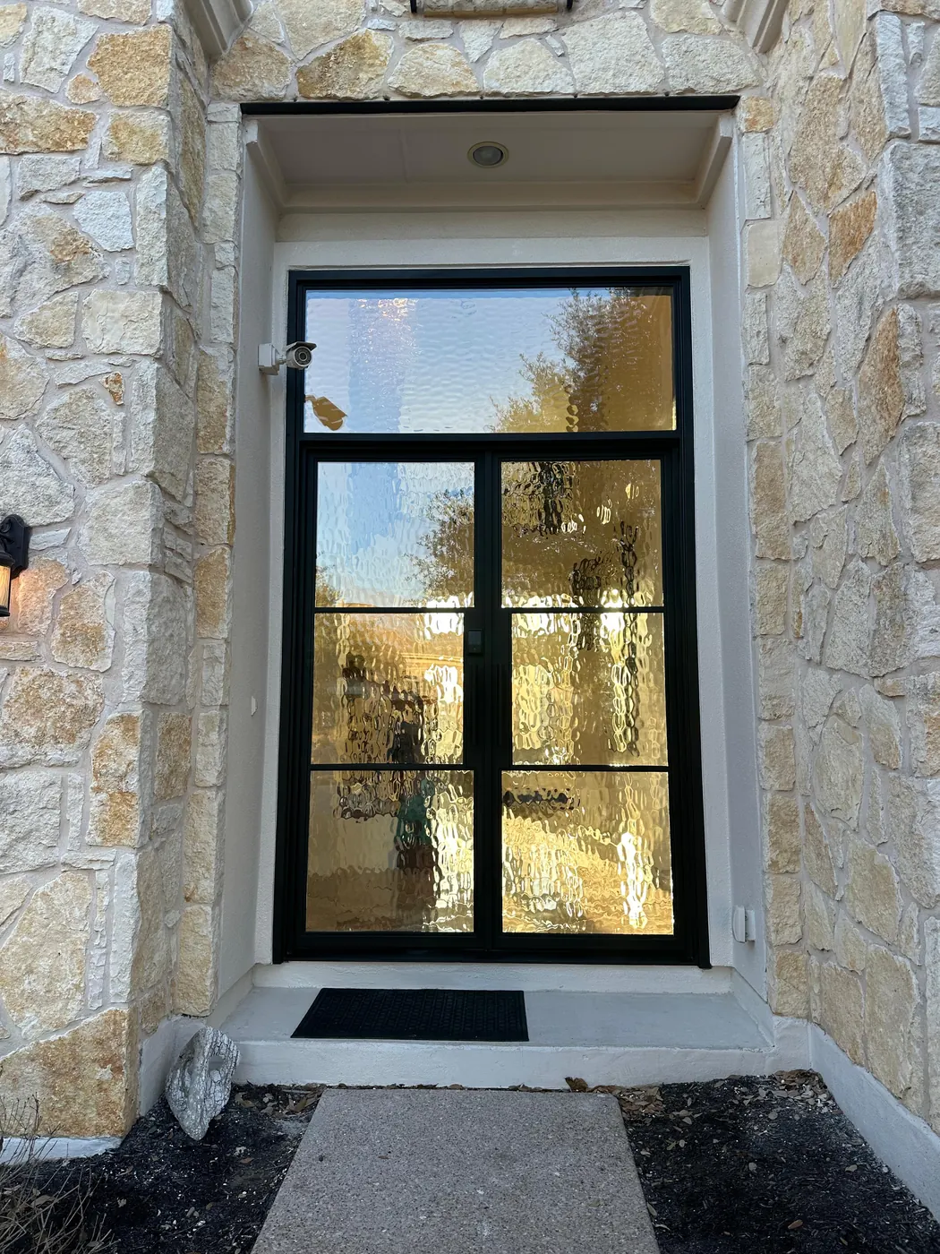 Steel entry door with transom window glazed full height at a Dripping Springs residence