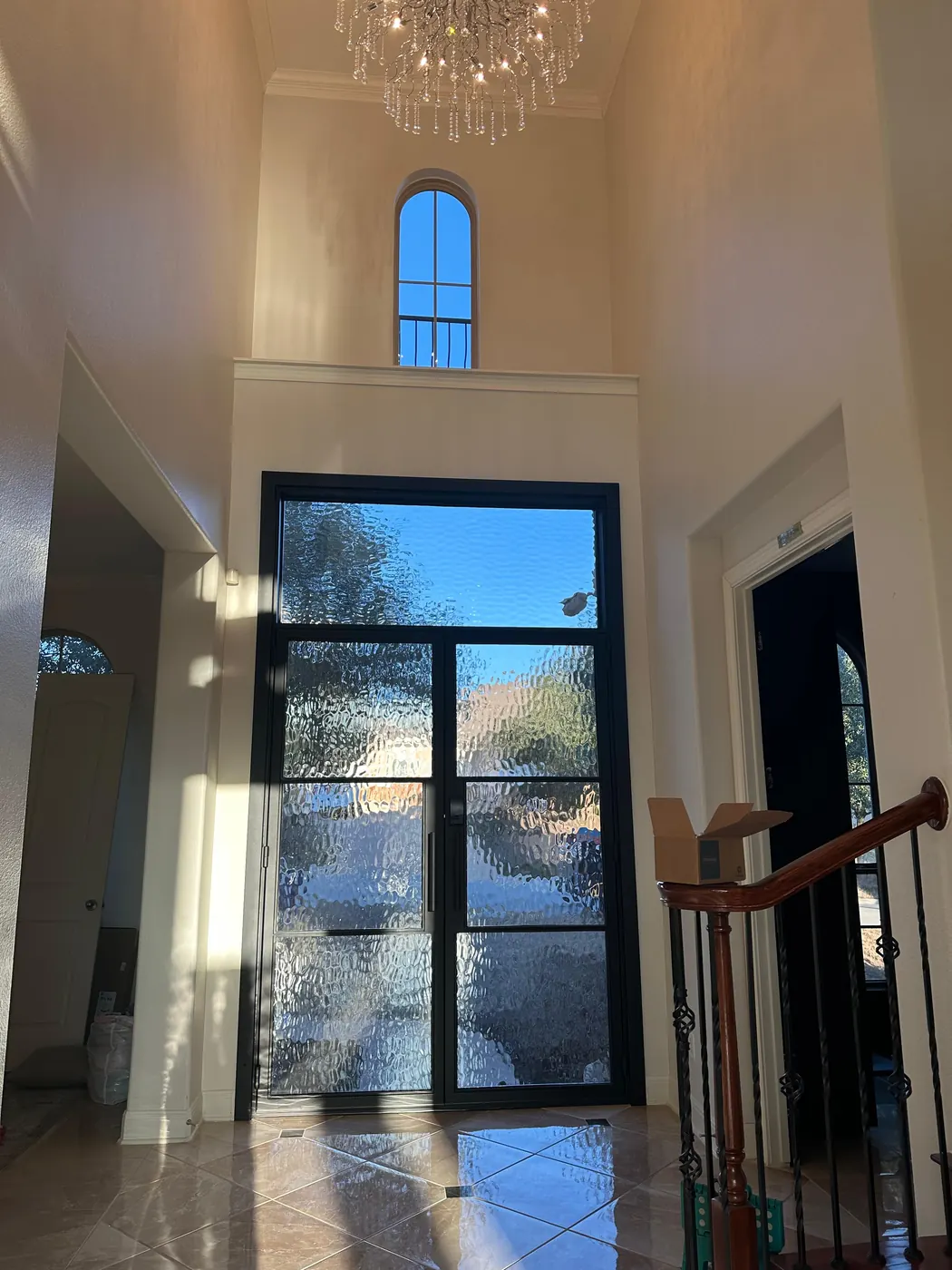 Two-story foyer filled with daylight after the steel entry door installation in Dripping Springs