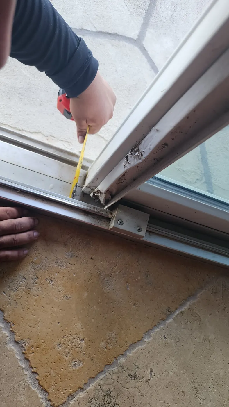 Installer measuring a steel door opening with a tape measure in Lakeway, TX