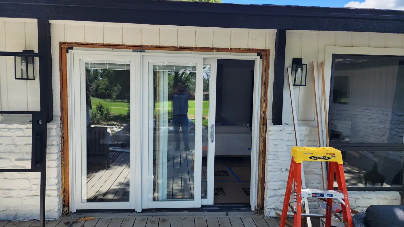 Original white framed patio doors on a Lakeway home before steel door replacement
