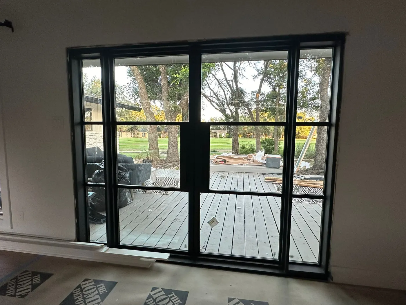 Steel French doors framing a golf course view from inside a Lakeway home